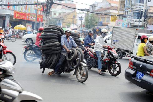 DFJ7E0 A man carry pile of tires on autobike in Ho Chi Minh City, Vietnam
